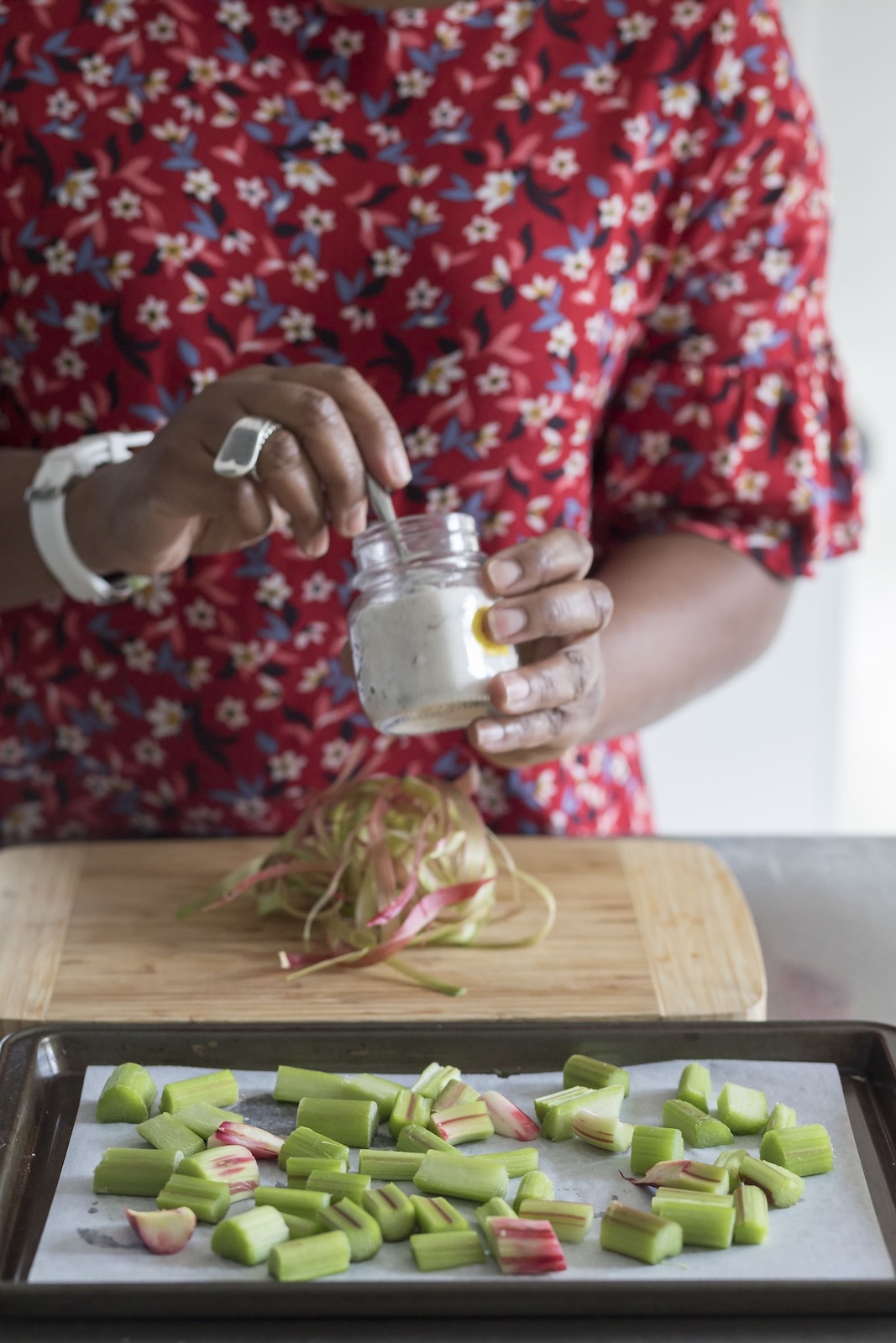 Jax Hamilton preparing fresh rhubarb, drizzling dressing during a recipe development session