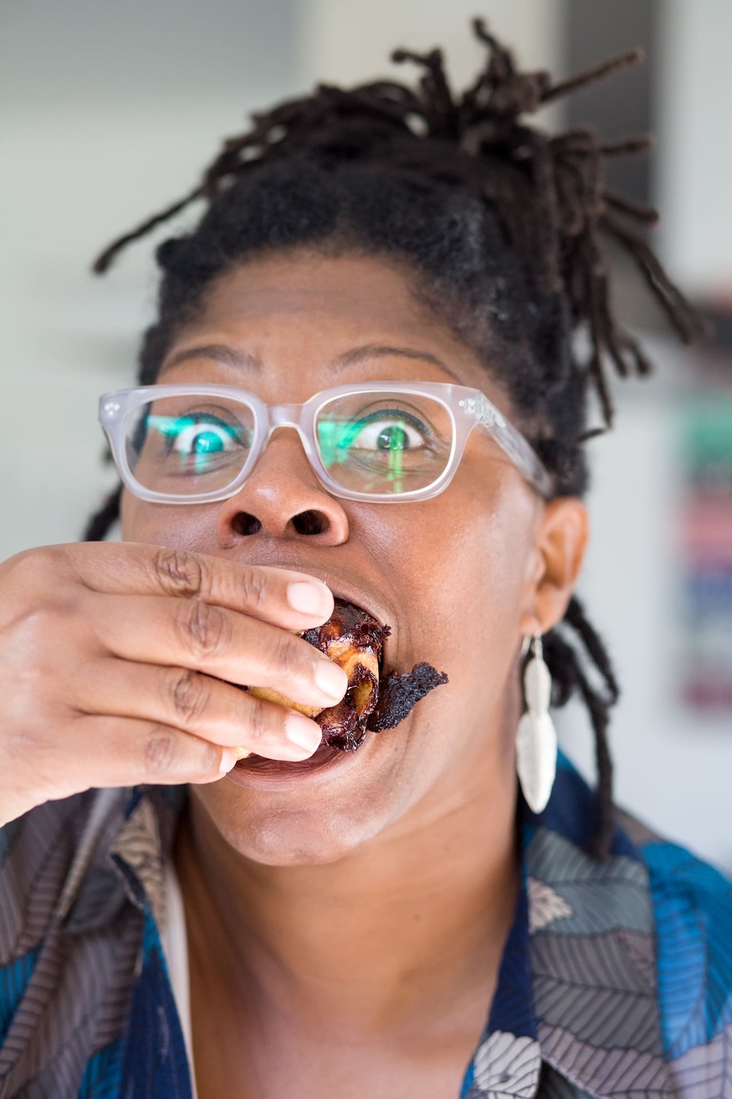 Jax Hamilton tasting food, biting into a piece of glazed meat with delight
