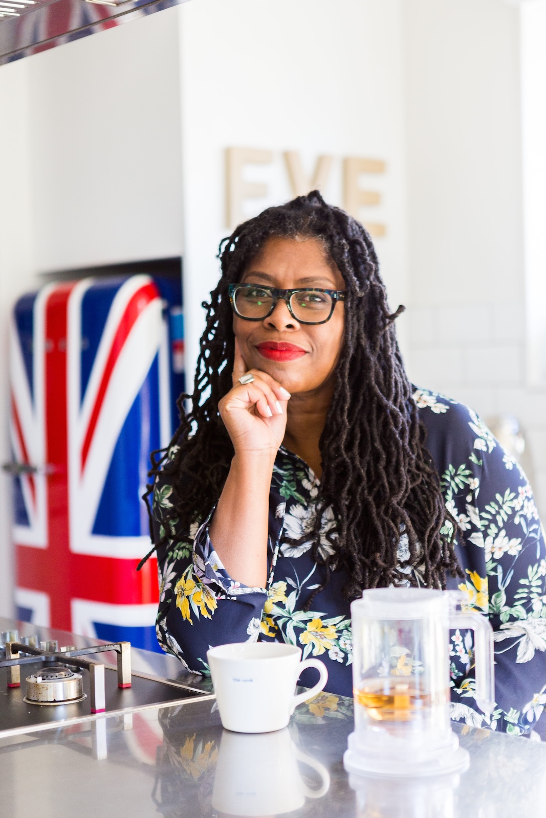 Jax Hamilton, New Zealand celebrity chef, thoughtful portrait in floral dress at the kitchen bench